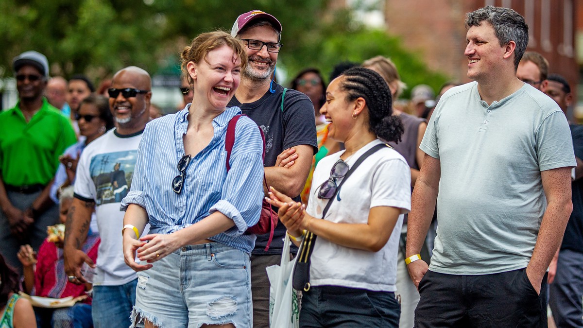A group of people conversing and laughing together outdoors.