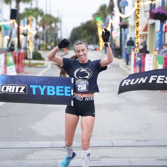 Woman crossing the finish line during the YMCA Critz Tybee Run Fest