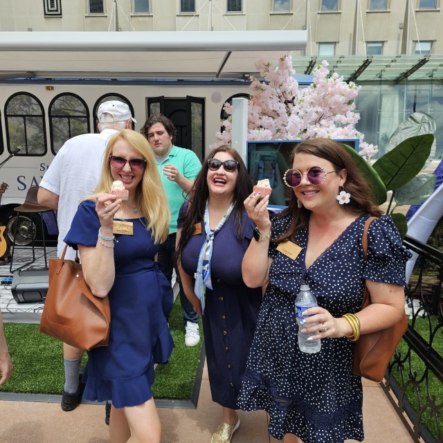 three ladies holding cupcakes