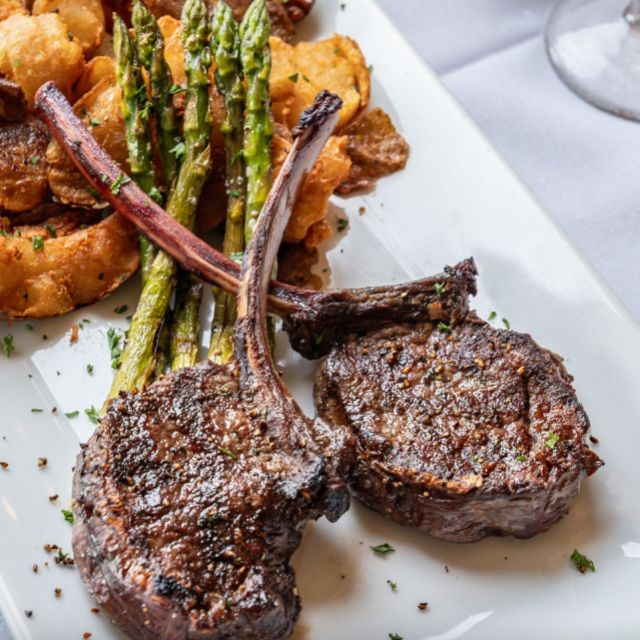 Steak and asparagus on a white platter.