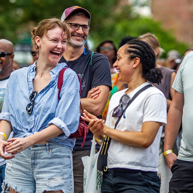 A group of people conversing and laughing together outdoors.