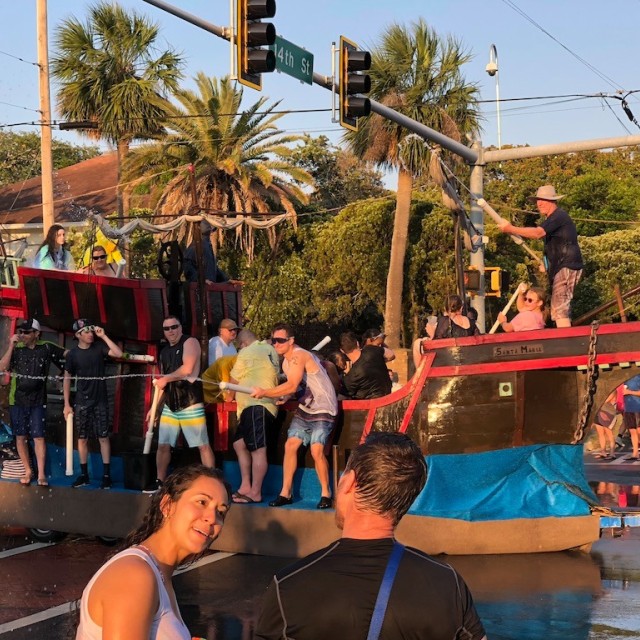 People on parade floats using water guns.