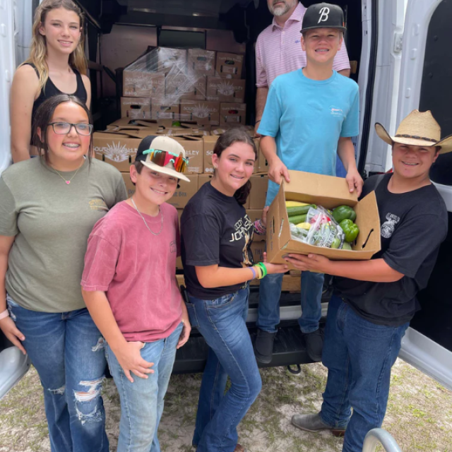 A family produce business with people loading a truck with food.
