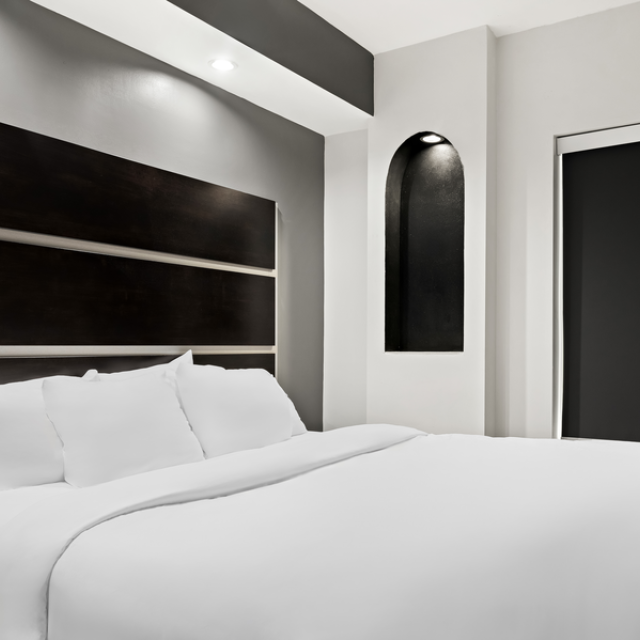 A modernized hotel room with black and white details.