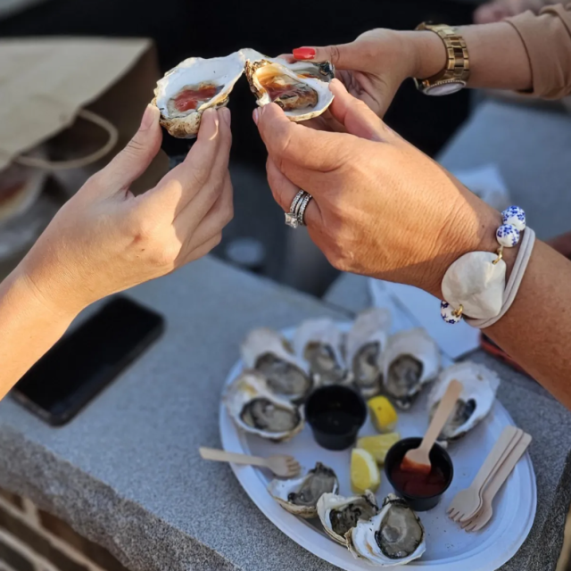 People enjoying oysters on a half shell.