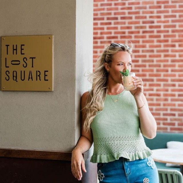 A woman having a cocktail outdoors.