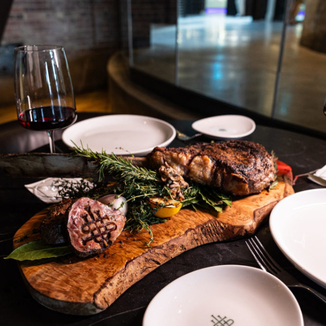 Steak served on a wooden platter.