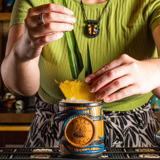 Hands of a bartender creating a lavish cocktail.