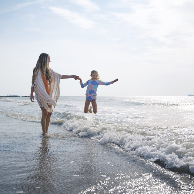 Mom and daughter playing in the ocean on Tybee Island, GA.