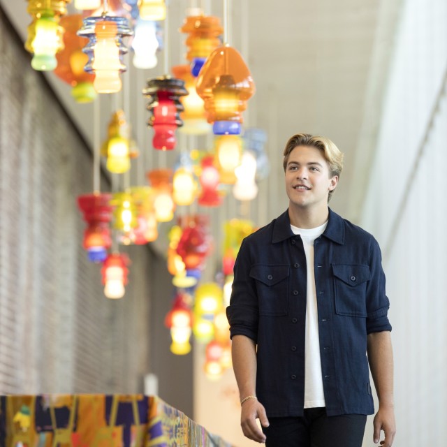 A young student walking through an art gallery.