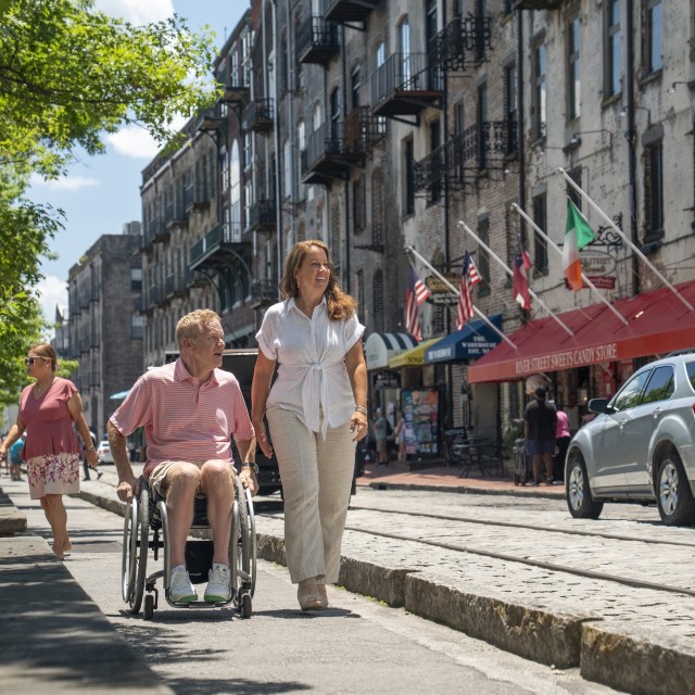 A man in a wheelchair with a woman on River Street, Savannah, GA.