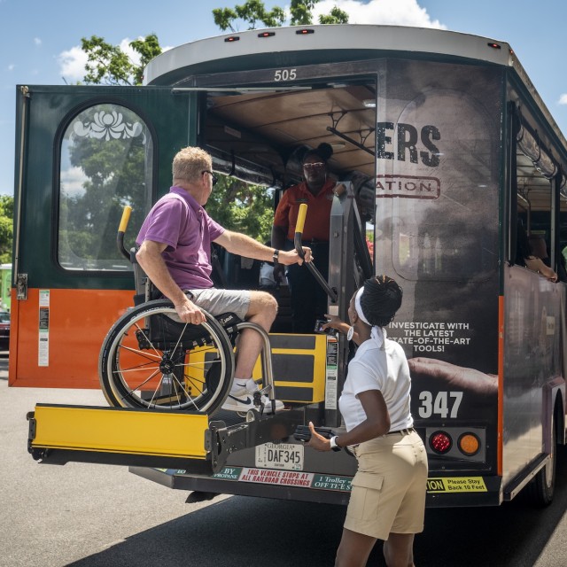 Wheelchair user using trolley bus chair lift.