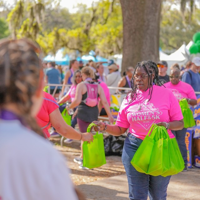 women handing out race bags