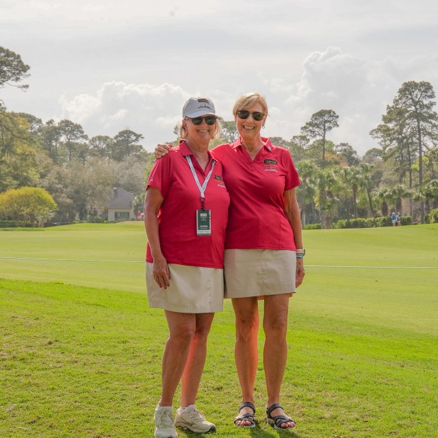 two women smiling at golf tournament