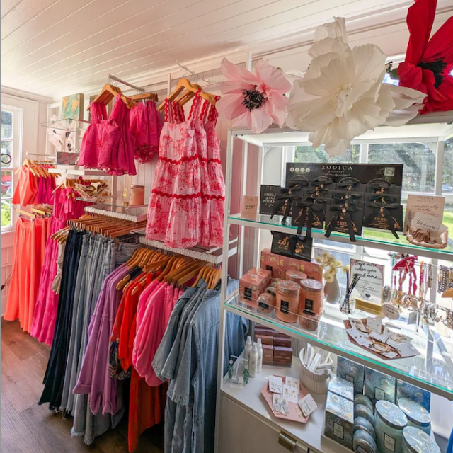 A boutique showing racks of clothes and accessories on shelves.