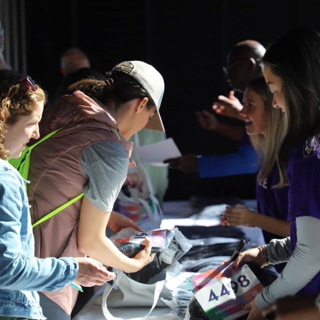 woman handing race bib