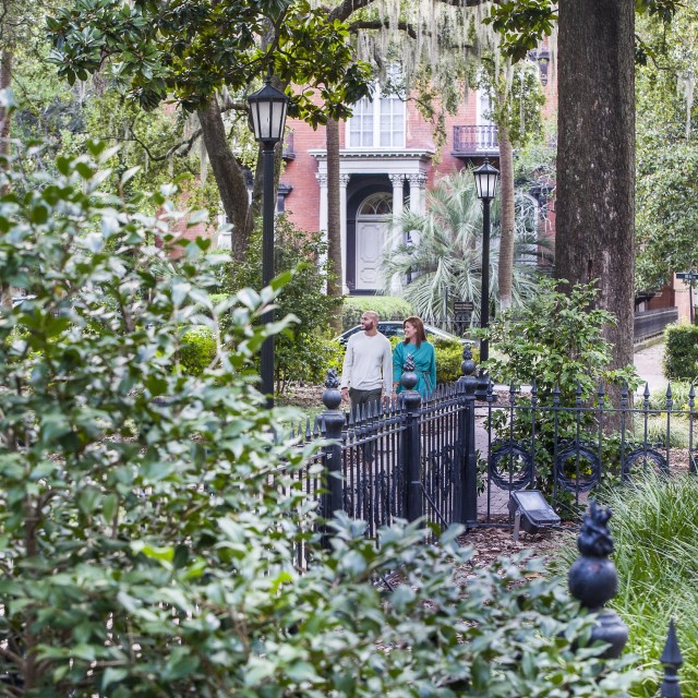 A couple enjoys a peaceful walk through one of Savannah’s iconic, oak-shaded squares.