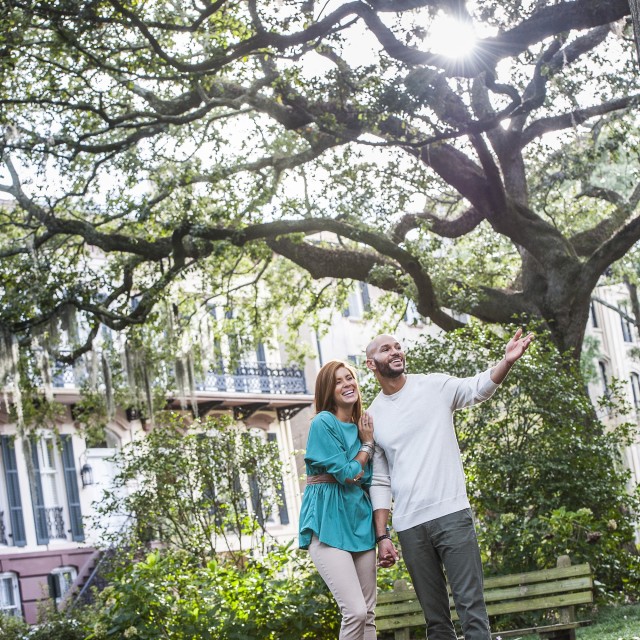 A couple strolling through Monterey Square in Savannah, GA.