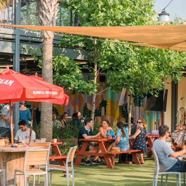 People gathering at picnic tables in the outdoor courtyard at Starland Yard.