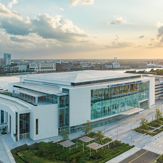 Aerial view of the Savannah Convention Center along the Savannah River at sunset, with the Talmadge Memorial Bridge and downtown skyline in the background.