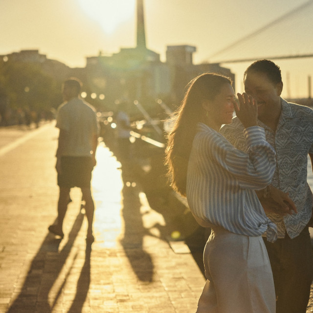 Couple sharing a moment along the Savannah riverfront at golden hour.