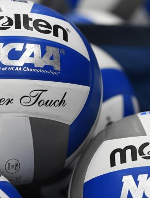 Numerous volleyballs piled together.