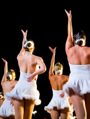 Holiday performers in sparkling white costumes dance along Savannah’s waterfront, adding festive cheer to seasonal celebrations.
