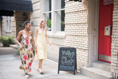Two friends walking towards a vintage shop.