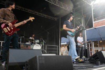 Musicians onstage singing and playing guitar.