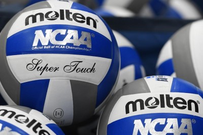 Numerous volleyballs piled together.