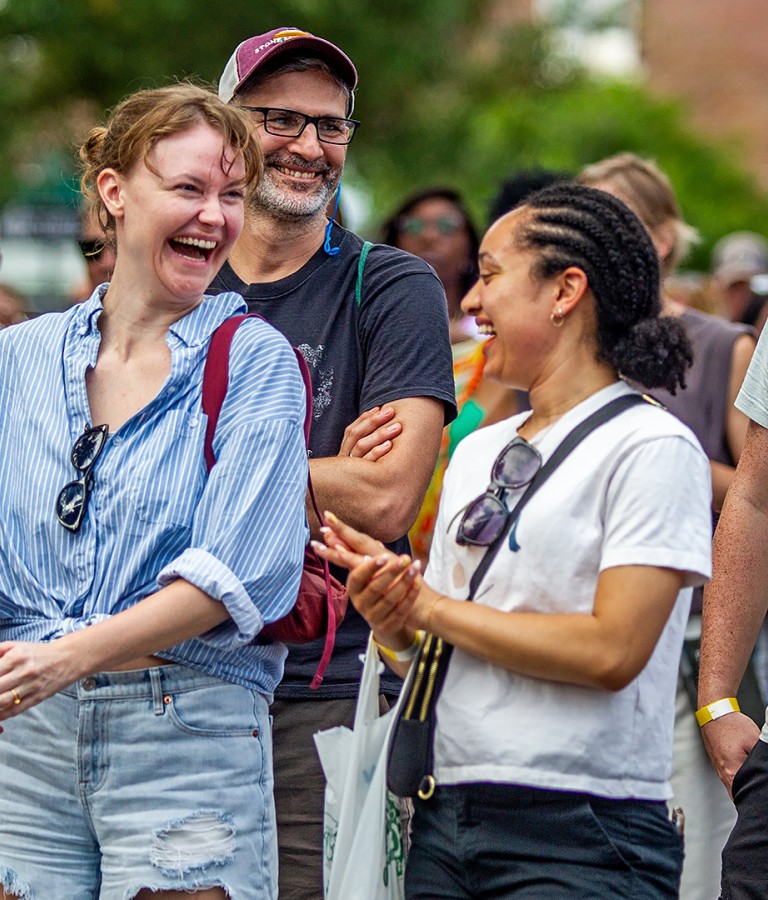 A group of people conversing and laughing together outdoors.