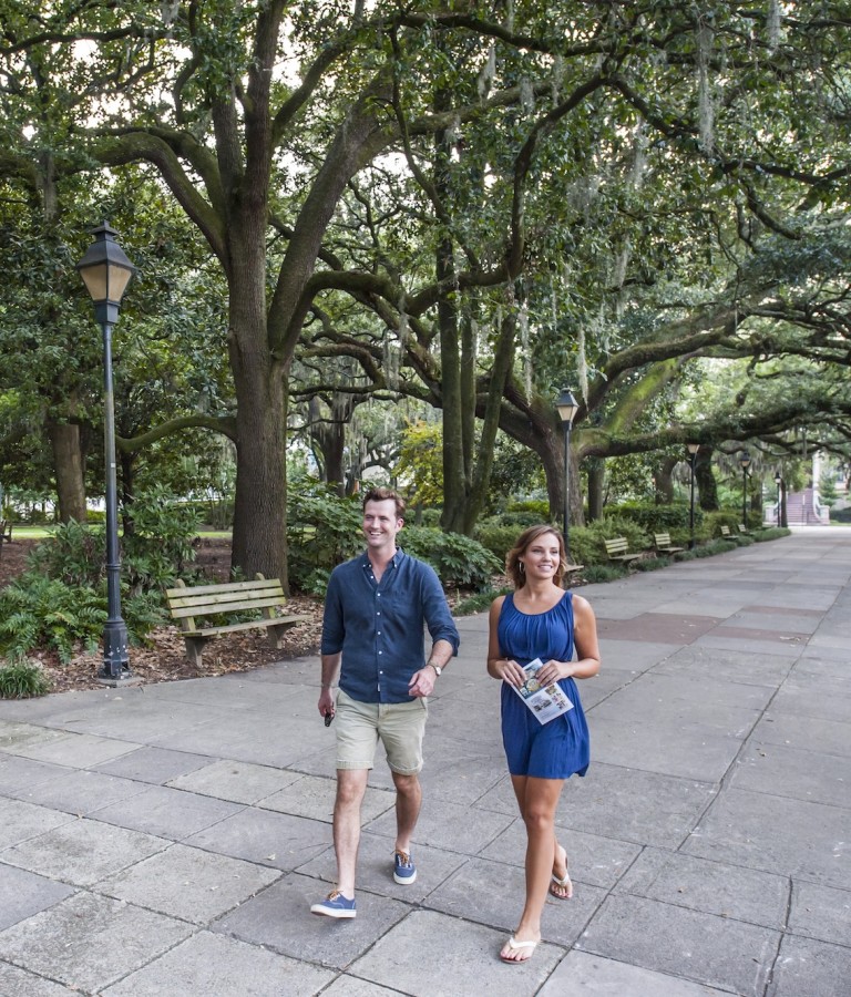 A couple walking the north end of Forsyth Park in Savannah, GA
