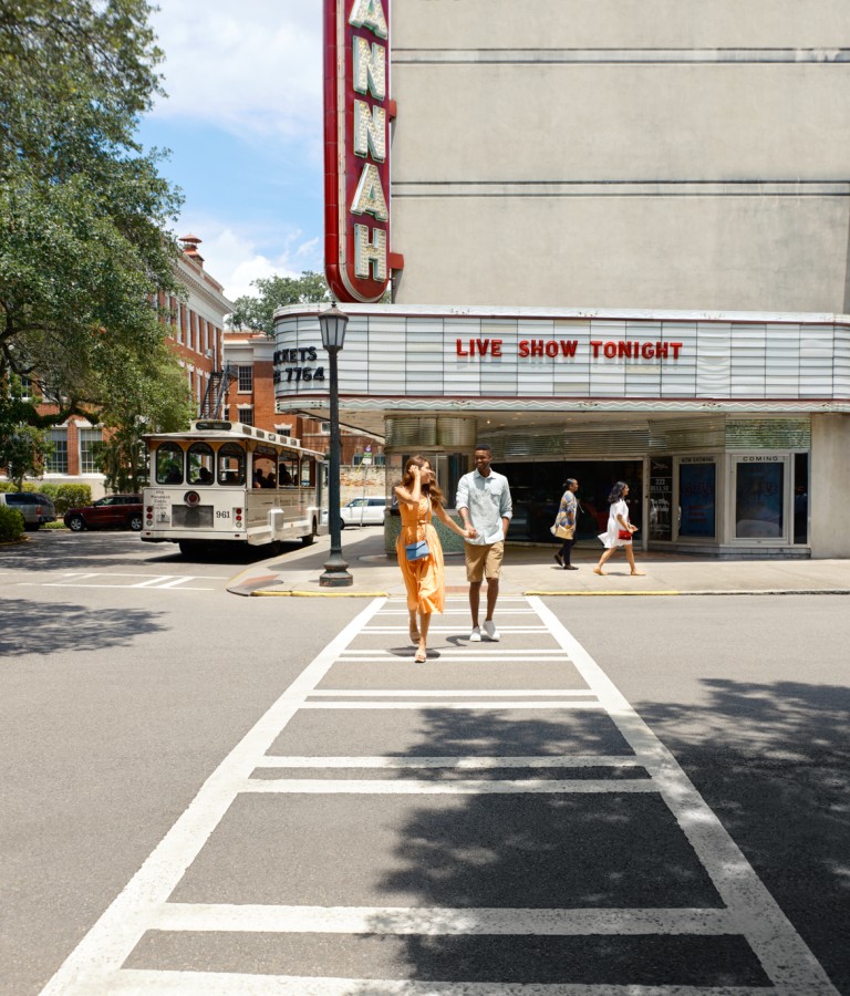 A young couple walking away from the Savannah Theatre in Savannah, GA.