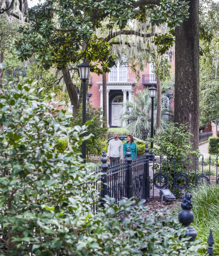 A couple enjoys a peaceful walk through one of Savannah’s iconic, oak-shaded squares.