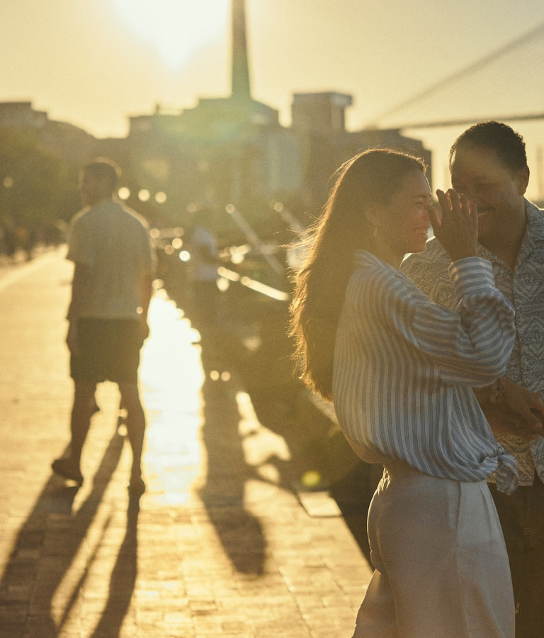 Couple sharing a moment along the Savannah riverfront at golden hour.