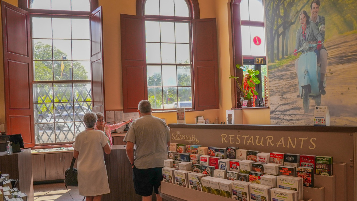 two visitors inside the visitor center with racks of brochures