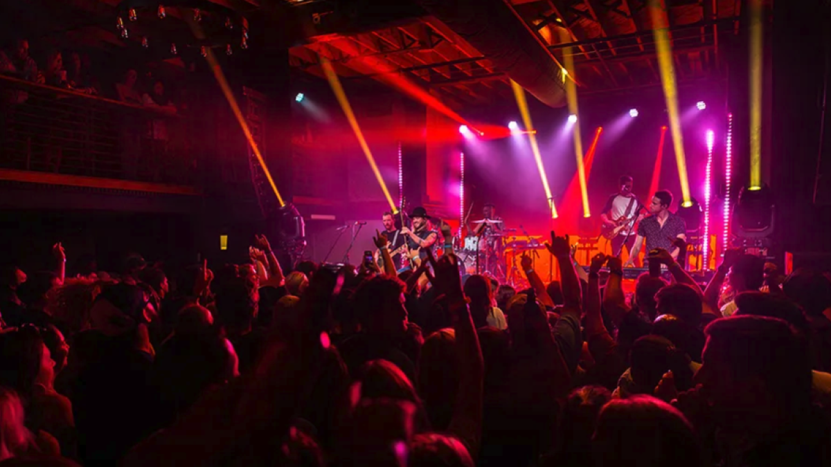 Live music concert venue filled with people and music artist on stage