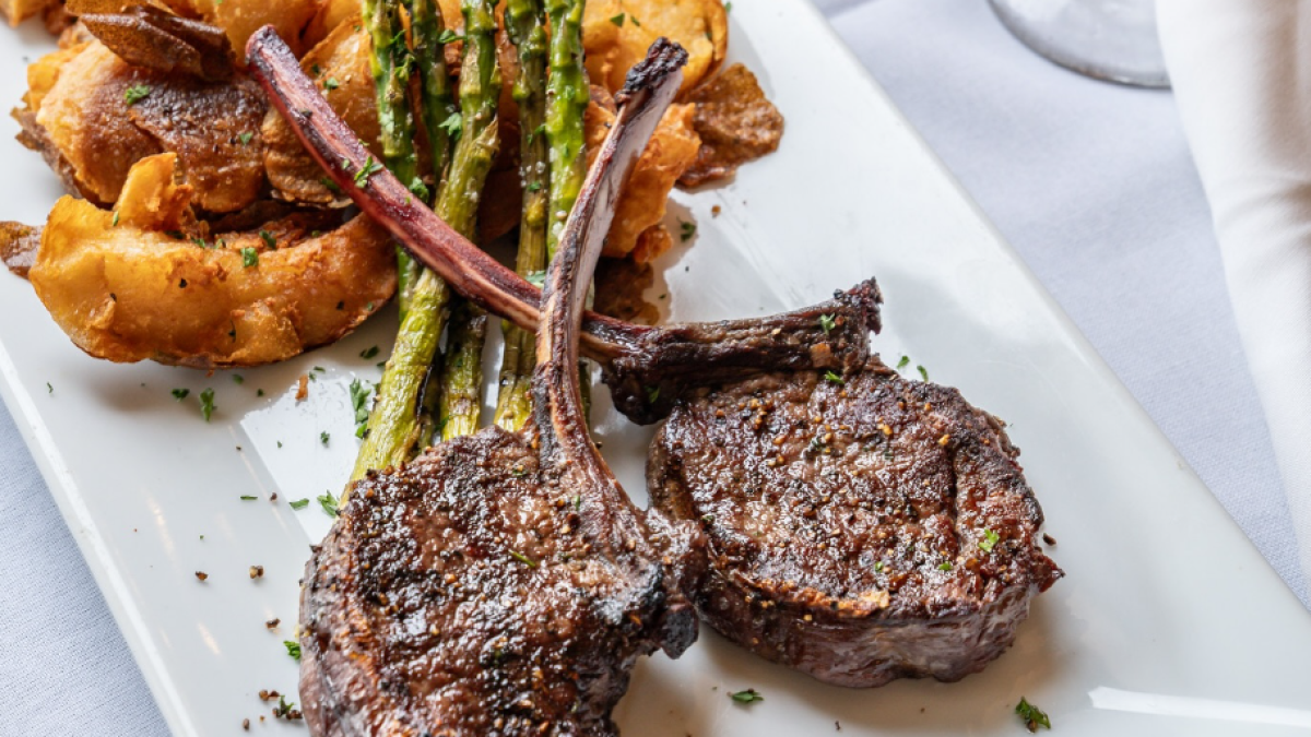 Steak and asparagus on a white platter.