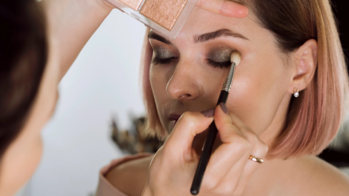 A makeup artist applying makeup to a woman’s face