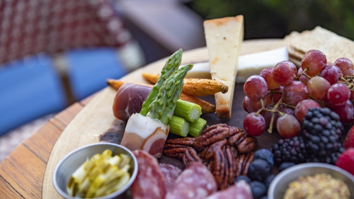 A charcuterie board with fruit, cheese and meat
