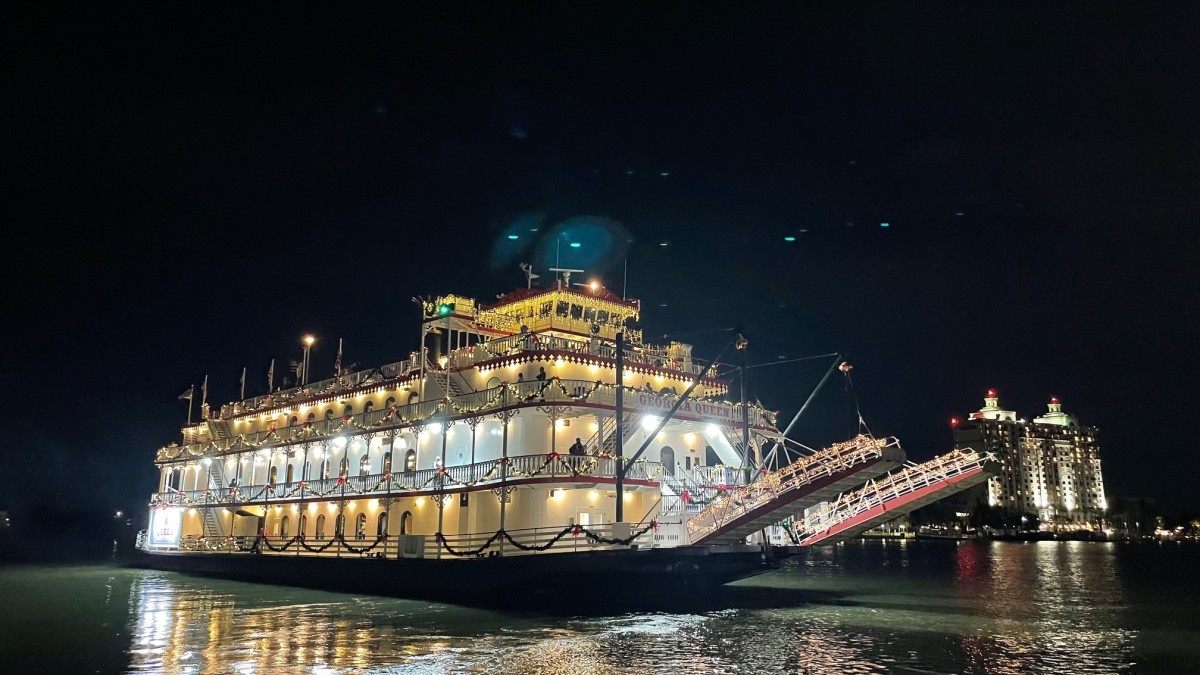 A large riverboat in the ocean at night.