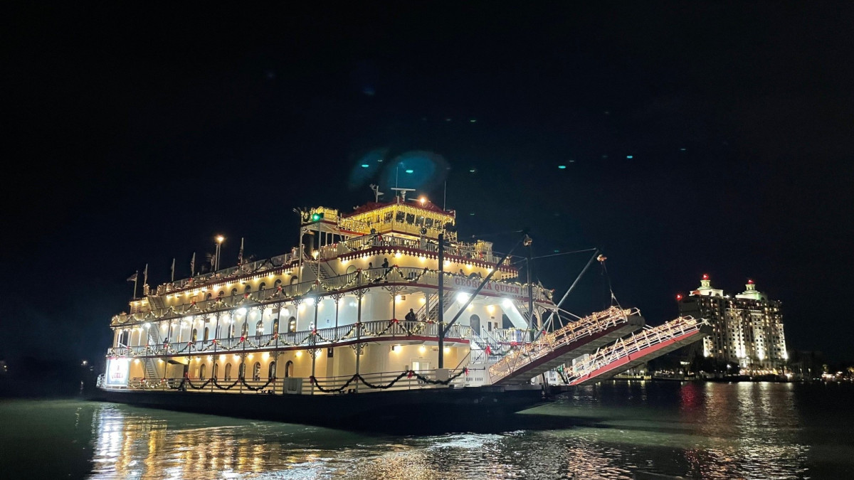 A large riverboat in the ocean at night.