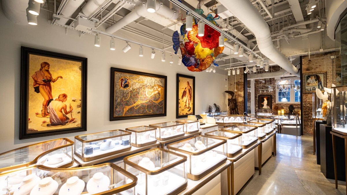 A large desinger jewelry store with fine art on the walls.