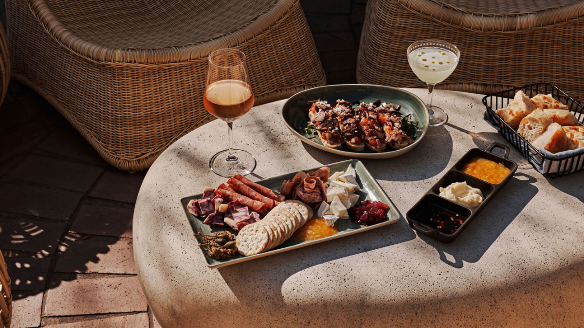 Several antipasta dishes on a table in an outdoor setting.