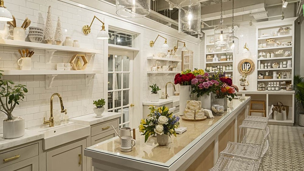 A white showroom with botanical arrangements and home decor.