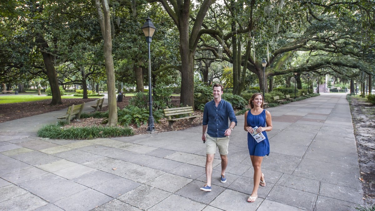 A couple walking the north end of Forsyth Park in Savannah, GA