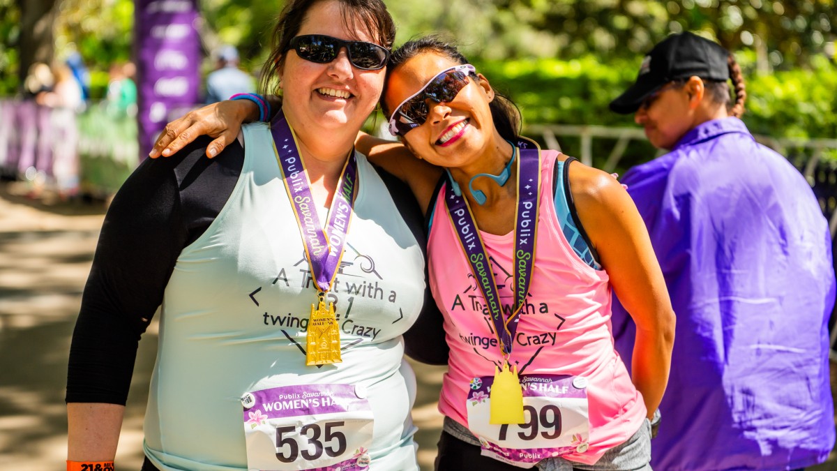 two runners smiling with medals