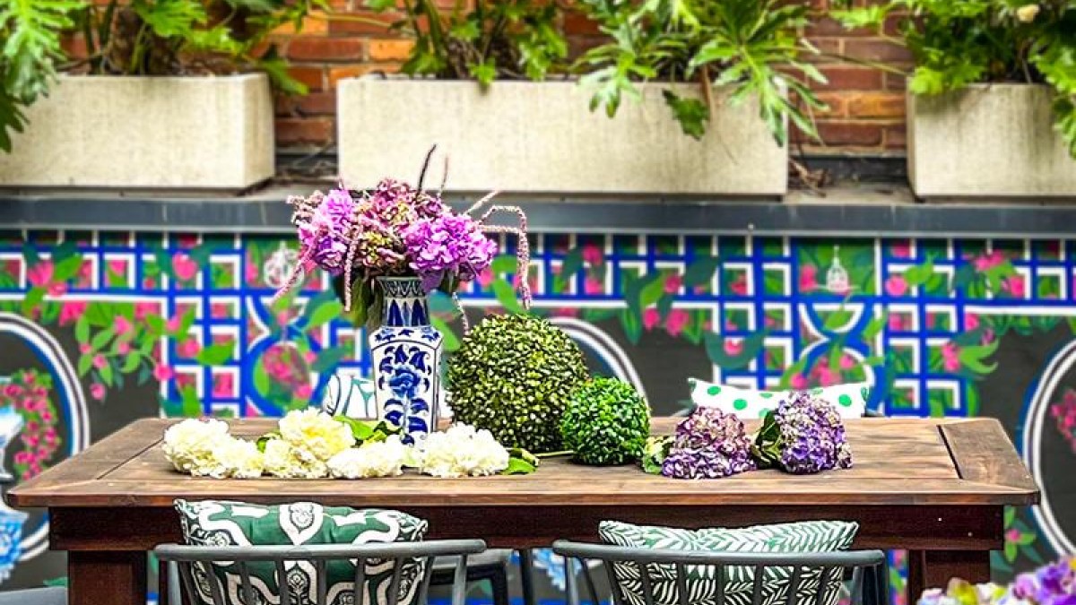 A rooftop bar with Mediterranean tile and bistro seating.