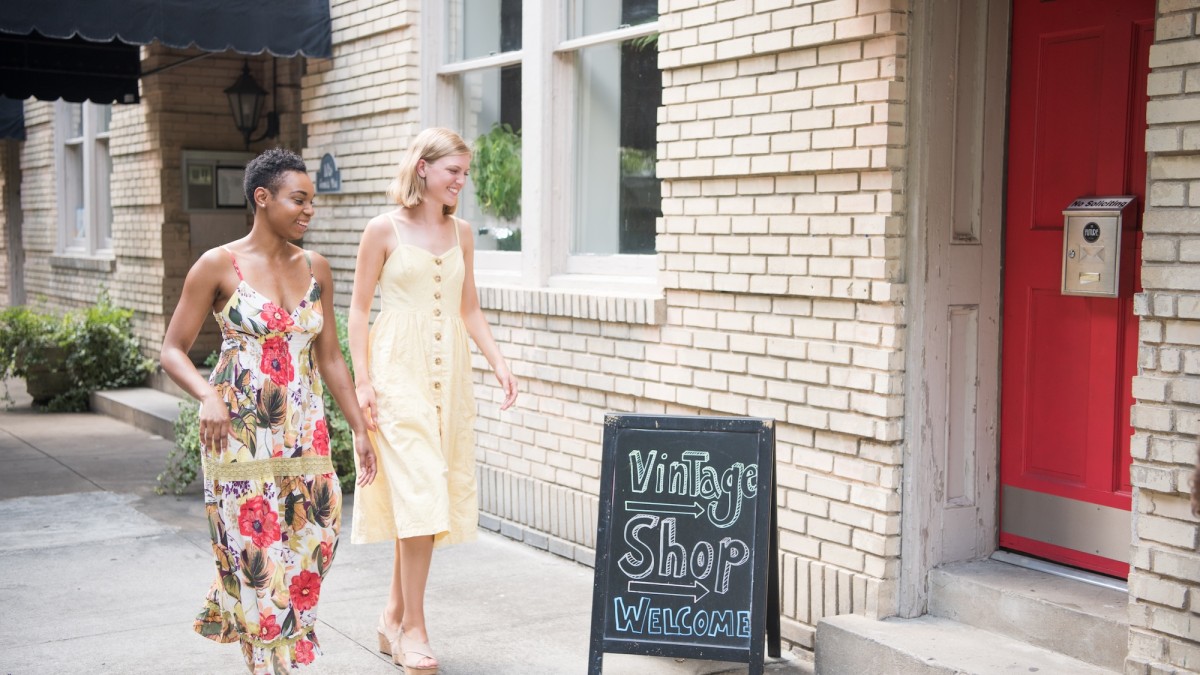 Two friends walking towards a vintage shop.