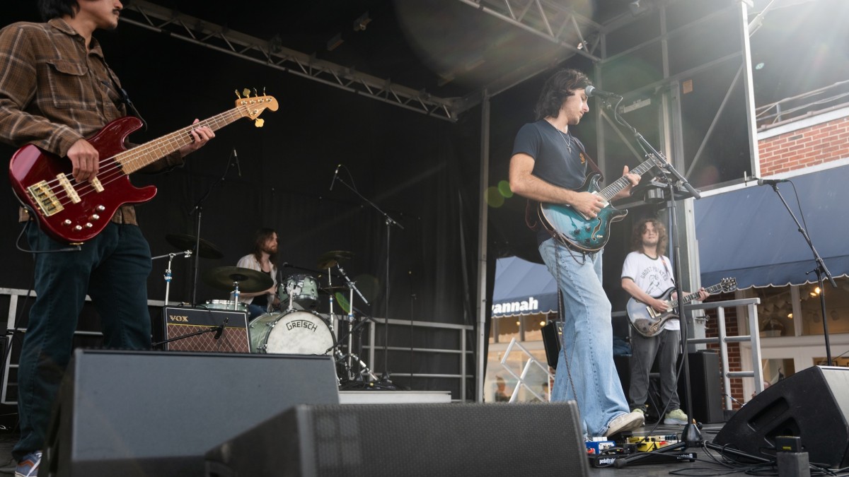 Musicians onstage singing and playing guitar.